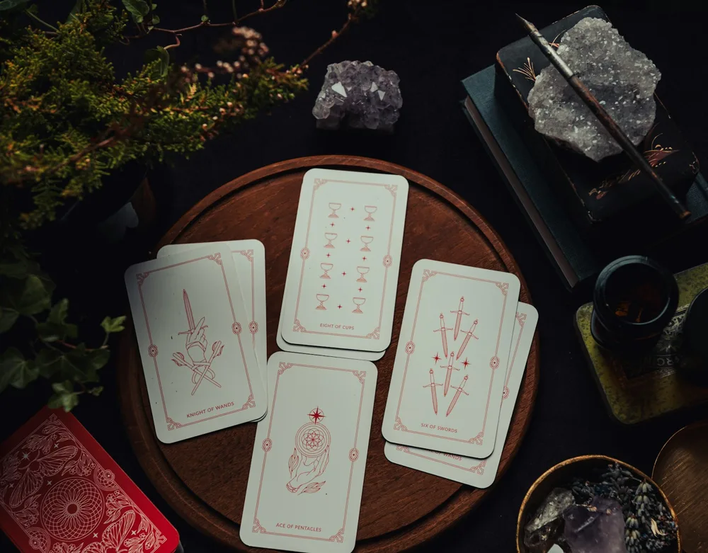 Tirada de Tarot sobre una bandeja de madera, acompañada de cristales.